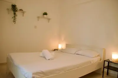 a white bed with two pillows and two lights at Yiallos Village Apt. A101 in Meneou