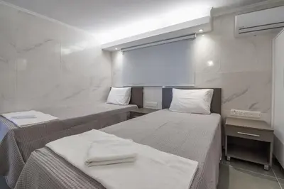 two beds in a room with white walls at Gevoni Deluxe Suites in Ayia Napa