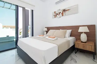 a bedroom with a large white bed and a window at Villa Megan in Protaras
