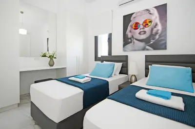 two beds in a room with blue and white at Villa Megan in Protaras