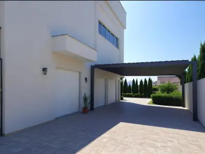 a white house with a garage and a driveway at Seaview Luxury Villas Ayia Napa in Ayia Napa