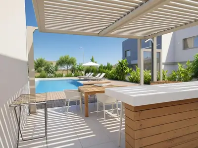 a patio with a table and chairs and a swimming pool at Seaview Luxury Villas Ayia Napa in Ayia Napa