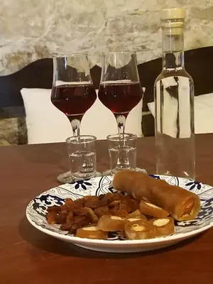 a plate of food and two glasses of wine at Ble Mavi - Studio for 2 in Vouni