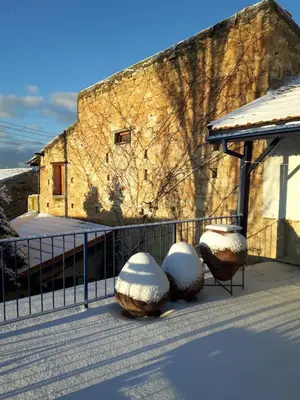 a building with some snow covered chairs and a fence at Ble Mavi - Studio for 2 in Vouni