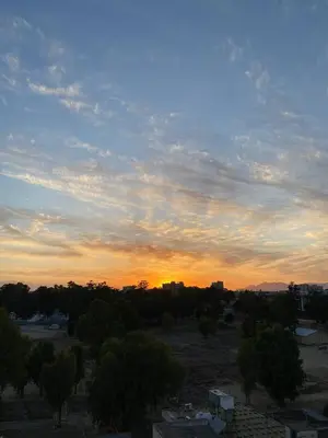 a sunset over a city with trees and buildings at Warm Residence in the heart of the City Center - Balcony & view in Nicosia