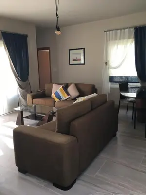 a living room with a brown couch and a table at Ocean View sunny retreat in Protaras