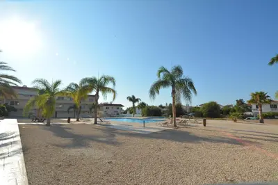 a resort with a swimming pool and palm trees at Nissi Martha Apartment in Ayia Napa