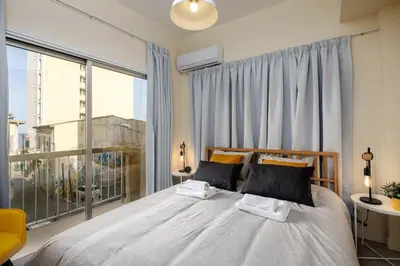 a bedroom with a bed and a large window at The Joy - Centre One Bedroom Flat in Larnaka