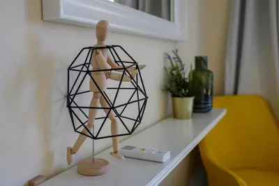 a wooden mannequin on a table next to a lamp at The Joy - Centre One Bedroom Flat in Larnaka