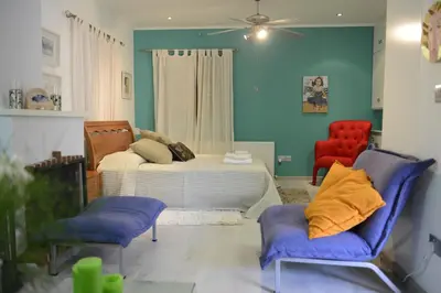 a living room with a bed and two chairs at Crambero Suites in Alona