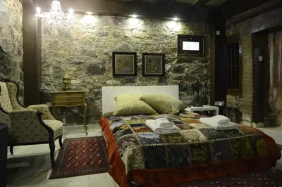 a bedroom with a bed and a stone wall at Crambero Suites in Alona
