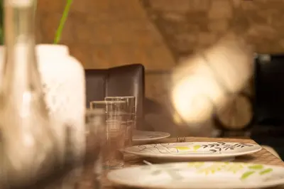 a table with two plates and glasses on it at Salamiou Stone House in Paphos City
