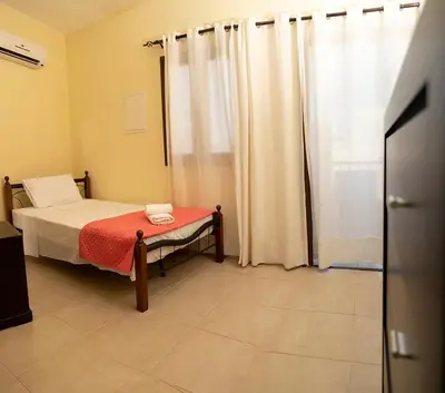 a bedroom with a bed and a window with curtains at Salamiou Stone House in Paphos City