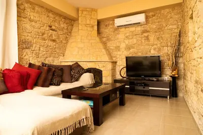 a living room with a couch and a tv at Salamiou Stone House in Paphos City