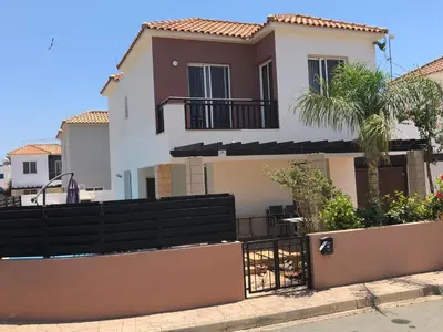 a house with a fence and a palm tree at Villa Lola in Ayia Napa