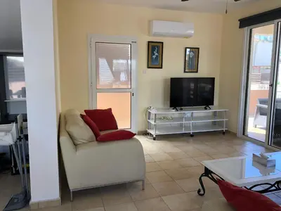 a living room with a couch and a tv at Villa Lola in Ayia Napa