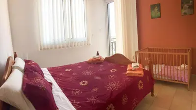 a bedroom with a crib with a purple blanket at Villa Lola in Ayia Napa