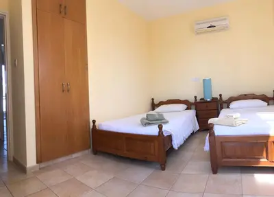 a bedroom with two twin beds and a closet at Villa Lola in Ayia Napa