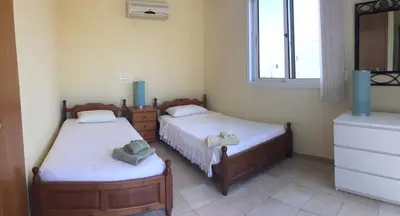 a bedroom with two beds and a window at Villa Lola in Ayia Napa