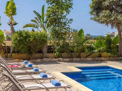 a pool with chairs and a swimming pool at Angel Villa in Ayia Napa