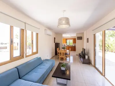 a living room with a blue couch and a table at Angel Villa in Ayia Napa