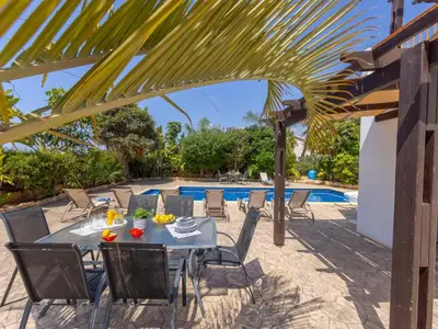 a patio with a table and chairs next to a pool at Angel Villa in Ayia Napa