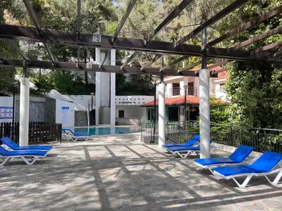 a group of blue lounge chairs in front of a swimming pool at POED Residences in Platres