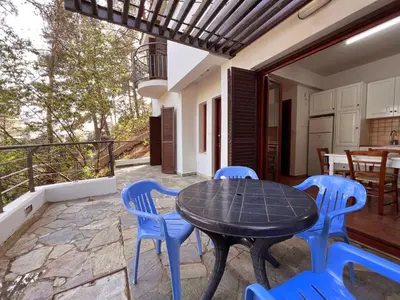 a patio with a black table and blue chairs at POED Residences in Platres