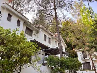 a white building with black balconies and trees at POED Residences in Platres