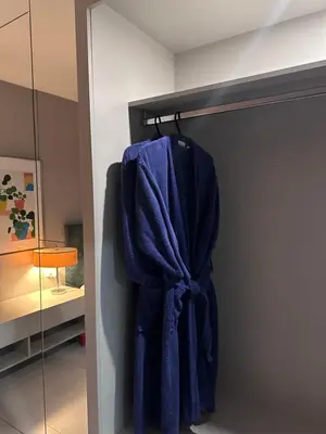 a blue robe hanging on a rack in a room at Levante Holiday Apartments in Larnaka