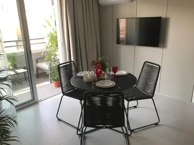 a black table with chairs and a television in a room at Levante Holiday Apartments in Larnaka