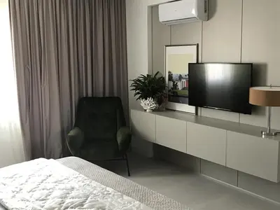a bedroom with a bed and a tv and a chair at Levante Holiday Apartments in Larnaka