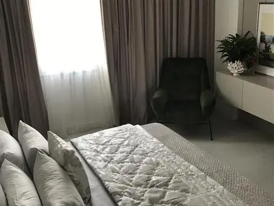 a bedroom with a bed and a chair and a window at Levante Holiday Apartments in Larnaka