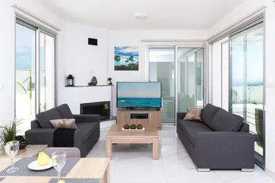 a living room with two couches and a flat screen tv at Villa Rubi in Ayia Napa