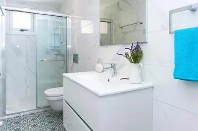 a white bathroom with a sink and a shower at Villa Rubi in Ayia Napa