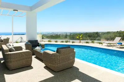 a patio with chairs and a swimming pool at Villa Rubi in Ayia Napa