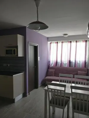 a living room with a couch and a table and chairs at Hawaii Royal Gardens in Limassol