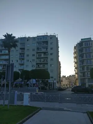 a large building with cars parked in a parking lot at Hawaii Royal Gardens in Limassol