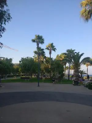 a park with palm trees and a person riding a bike at Hawaii Royal Gardens in Limassol