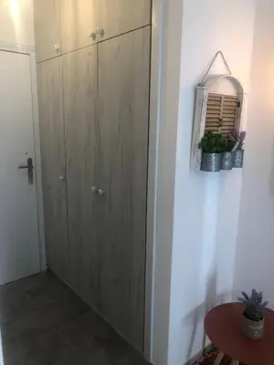 a hallway with a wooden door and a table at AgiaNapaNest studio in Ayia Napa