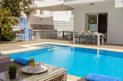 a swimming pool with a table and chairs next to it at Fig Tree Bay Residences 3-Jacuzzi-Hotub -Pool in Protaras