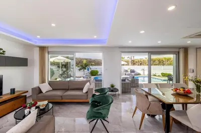 a living room with a couch and a table at Fig Tree Bay Residences 3-Jacuzzi-Hotub -Pool in Protaras