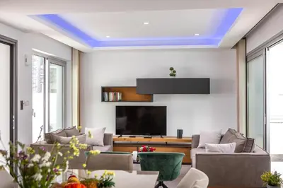 a living room with couches and a flat screen tv at Fig Tree Bay Residences 3-Jacuzzi-Hotub -Pool in Protaras