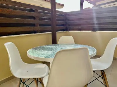 a room with a table and white chairs at Seana Villa Protaras in Paralimni