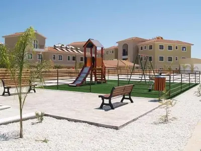 a park with a playground with benches and a slide at Seana Villa Protaras in Paralimni