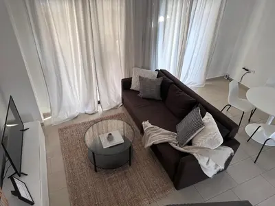 a living room with a brown couch and a table at Seana Villa Protaras in Paralimni