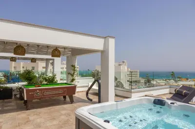a hot tub on a balcony with a pool table at Fig Tree Bay Residences 4 in Protaras