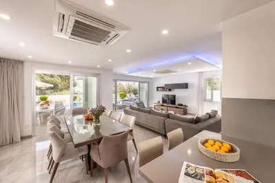 a dining room and living room with a table and chairs at Fig Tree Bay Residences 4 in Protaras