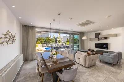 a dining room and living room with a table and chairs at Fig Tree Bay Residences 6 in Protaras