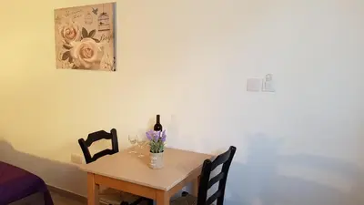 a dining room table with a bottle of wine and a wine glass at ZORBAS No 2 in Larnaka